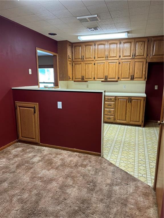 915 W 4th St, Chanute, KS 66720 - kitchen featuring brown cabinets, light carpet, and light countertops