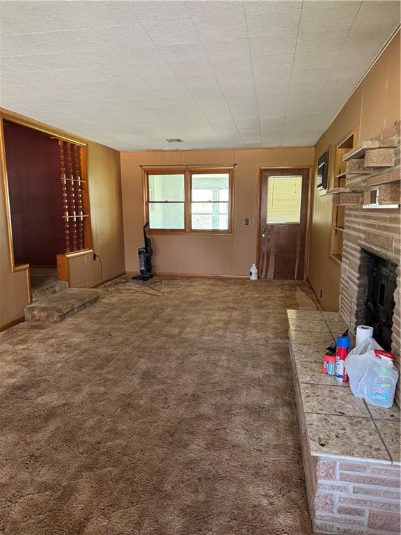 915 W 4th St, Chanute, KS 66720 - unfurnished living room with a fireplace and carpet floors