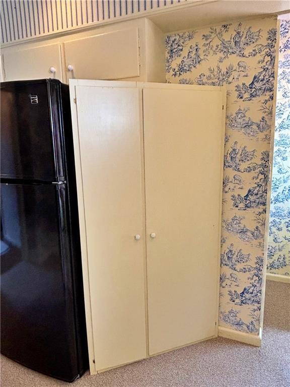 610 S Woodland St, Pittsburg, KS 66762 - unfurnished bedroom with freestanding refrigerator, light carpet, and wallpapered walls