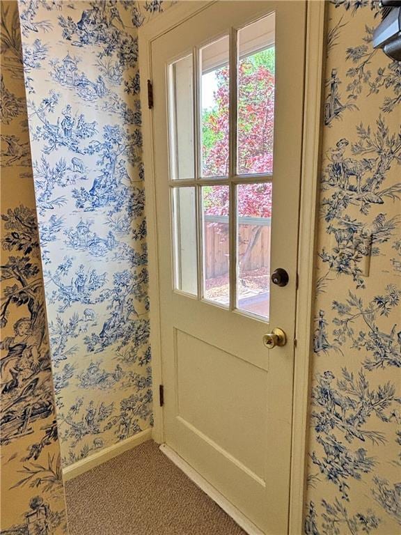610 S Woodland St, Pittsburg, KS 66762 - doorway to outside with wallpapered walls, carpet flooring, and baseboards