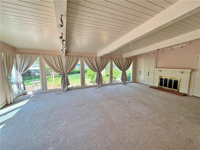 610 S Woodland St, Pittsburg, KS 66762 - unfurnished living room with beamed ceiling, carpet floors, track lighting, and a brick fireplace