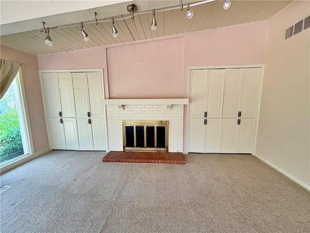 610 S Woodland St, Pittsburg, KS 66762 - unfurnished living room featuring carpet, track lighting, a fireplace, and baseboards