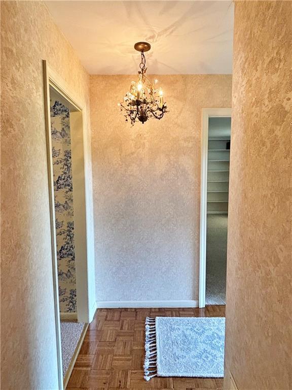 610 S Woodland St, Pittsburg, KS 66762 - unfurnished dining area with a chandelier and a textured wall