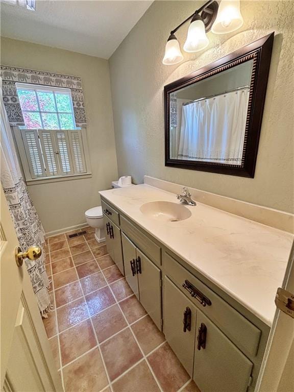 610 S Woodland St, Pittsburg, KS 66762 - full bath featuring vanity, toilet, baseboards, tile patterned flooring, and a textured wall