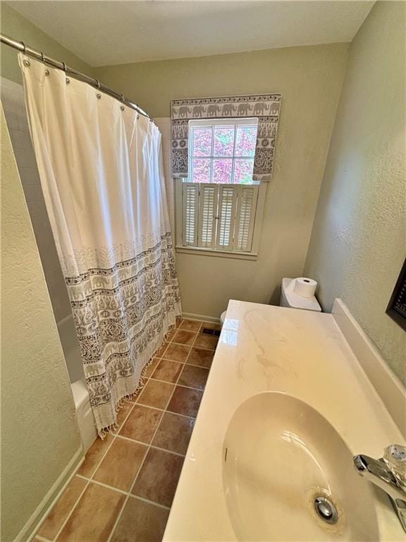 610 S Woodland St, Pittsburg, KS 66762 - full bath with a sink, tile patterned flooring, shower / tub combo, baseboards, and a textured wall