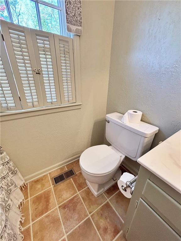 610 S Woodland St, Pittsburg, KS 66762 - bathroom with toilet, baseboards, vanity, a textured wall, and tile patterned floors