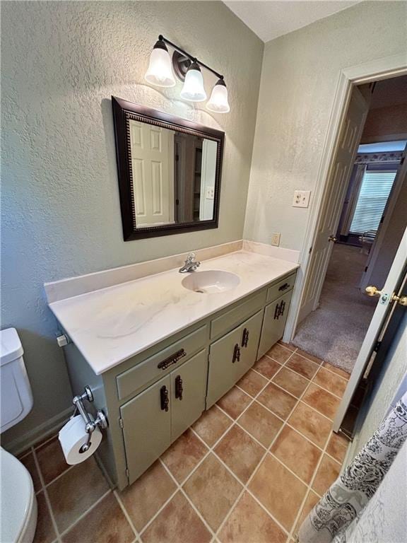 610 S Woodland St, Pittsburg, KS 66762 - bathroom with toilet, tile patterned flooring, a textured wall, and vanity