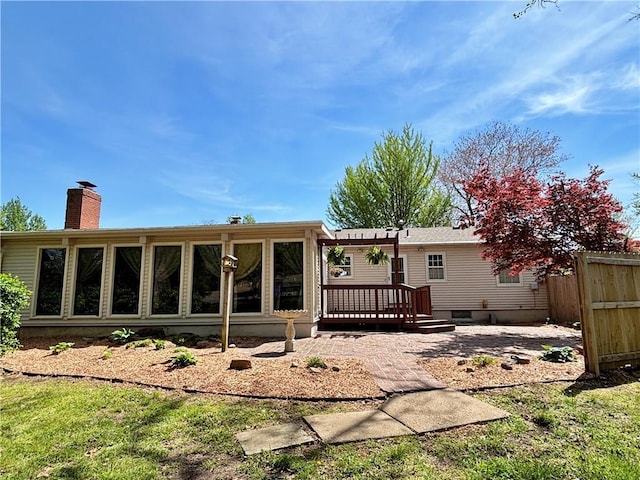 610 S Woodland St, Pittsburg, KS 66762 - back of house with a wooden deck, fence, and a chimney