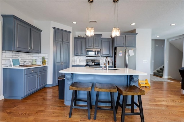 1008 SW Whippoorwill Ln, Oak Grove, MO 64075 - kitchen with appliances with stainless steel finishes, backsplash, a breakfast bar, light countertops, and recessed lighting
