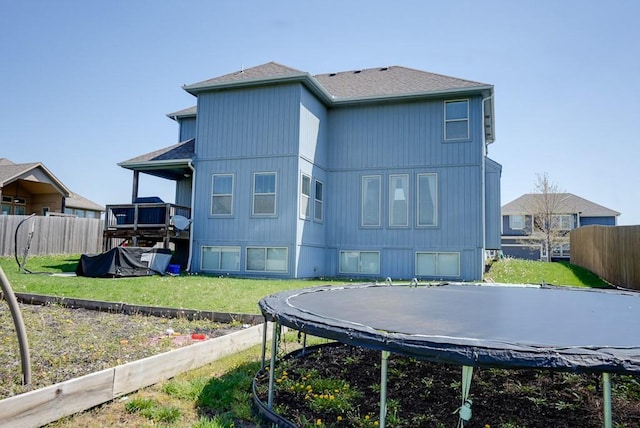 1008 SW Whippoorwill Ln, Oak Grove, MO 64075 - rear view of house with a trampoline and a shingled roof