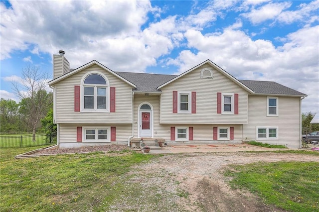 12448 NW Blackwood Dr, Adrian, MO 64720 - raised ranch with a front yard, a chimney, and fence
