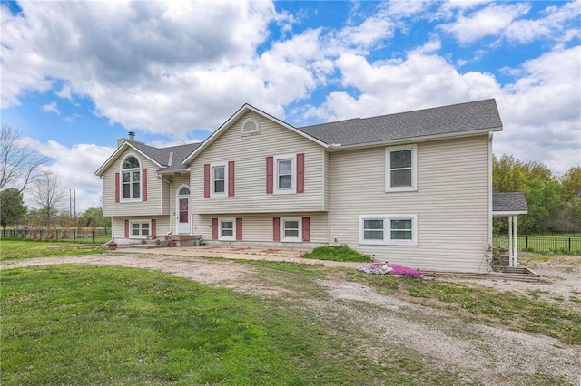 12448 NW Blackwood Dr, Adrian, MO 64720 - split foyer home featuring fence, a shingled roof, a front lawn, and a chimney