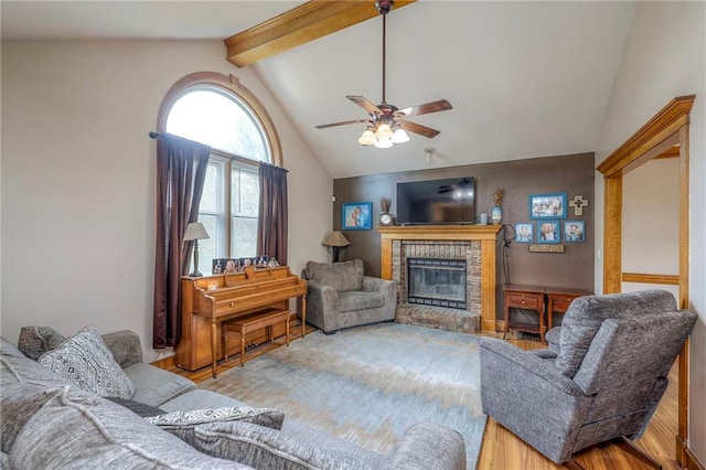 12448 NW Blackwood Dr, Adrian, MO 64720 - living room with vaulted ceiling with beams, wood finished floors, a ceiling fan, and a brick fireplace