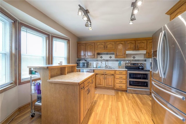 12448 NW Blackwood Dr, Adrian, MO 64720 - kitchen with a sink, light countertops, appliances with stainless steel finishes, light wood-style flooring, and under cabinet range hood