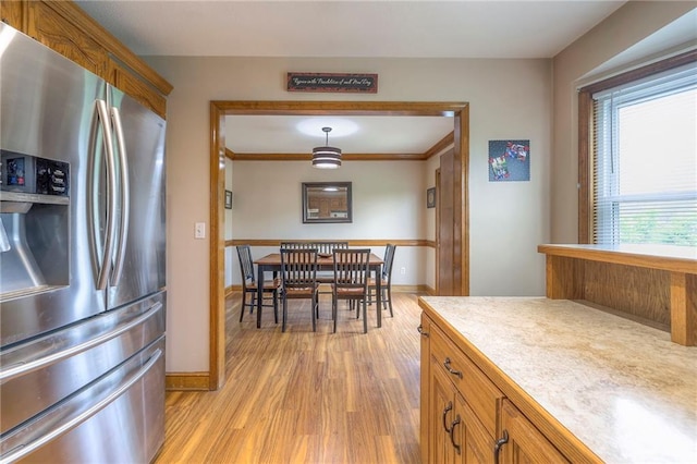 12448 NW Blackwood Dr, Adrian, MO 64720 - kitchen featuring brown cabinets, light wood finished floors, light countertops, baseboards, and stainless steel refrigerator with ice dispenser