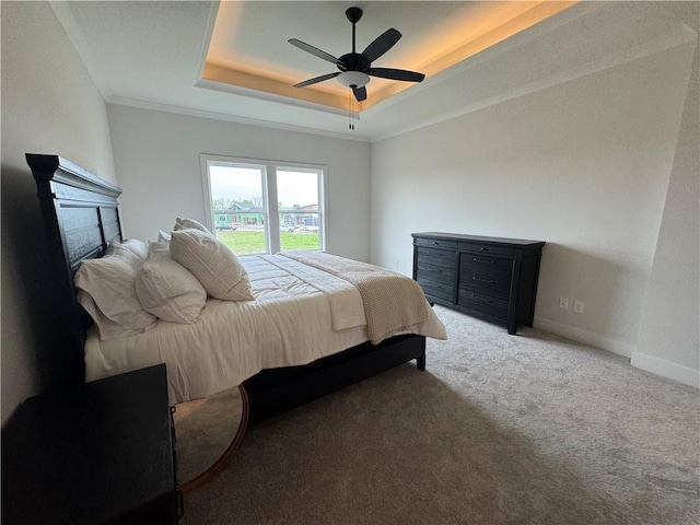 bedroom with carpet flooring, a raised ceiling, ceiling fan, baseboards, and a fireplace