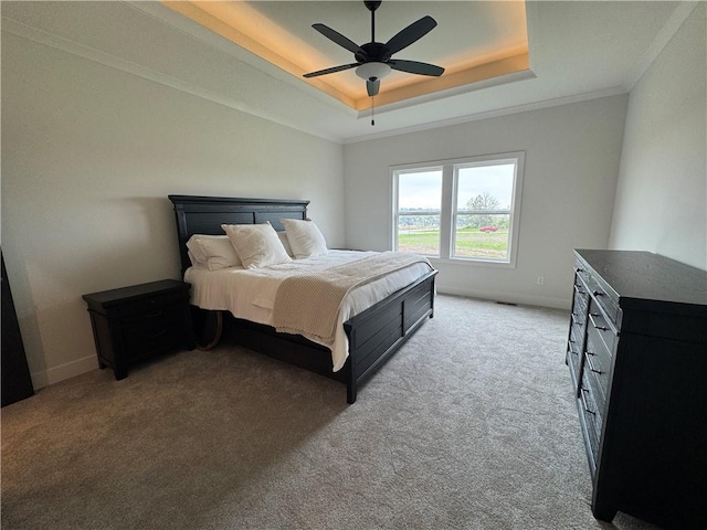 bedroom featuring crown molding, a raised ceiling, baseboards, light carpet, and a ceiling fan