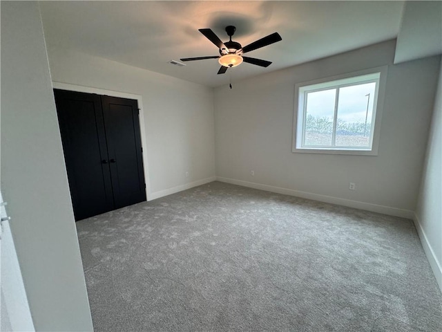 unfurnished bedroom with carpet floors, visible vents, a closet, and baseboards