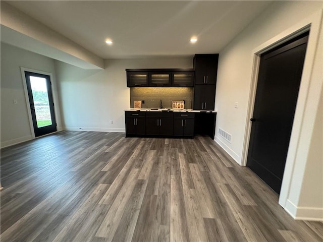 bar with dark wood-style floors, visible vents, and baseboards