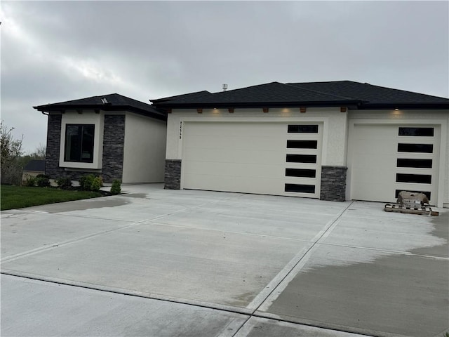 prairie-style house with stucco siding, driveway, an attached garage, and stone siding