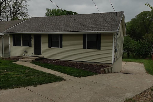 view of front facade featuring a front yard and roof with shingles