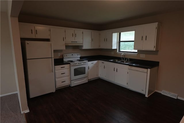 kitchen featuring visible vents, dark countertops, white appliances, and under cabinet range hood