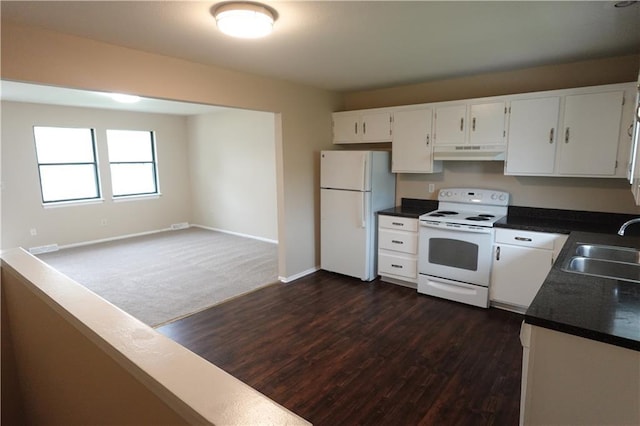 kitchen featuring white cabinets, a sink, under cabinet range hood, dark wood finished floors, and white appliances
