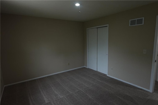 unfurnished bedroom featuring dark carpet, visible vents, a closet, baseboards, and recessed lighting