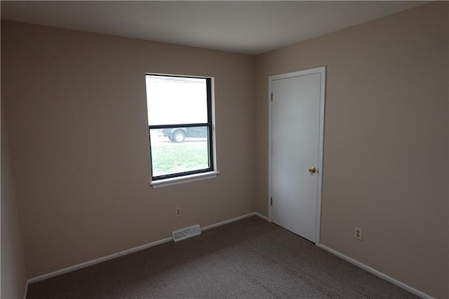 unfurnished room with baseboards, visible vents, and carpet