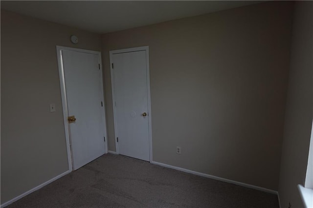 spare room with baseboards and carpet