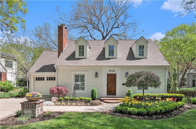 cape cod house with an attached garage, roof with shingles, a chimney, and concrete driveway