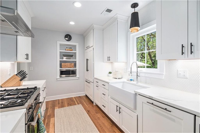 kitchen with a sink, tasteful backsplash, stainless steel appliances, and visible vents