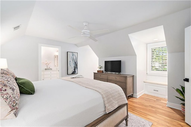 bedroom with light wood-style floors, ensuite bathroom, lofted ceiling, and visible vents