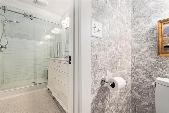 bathroom featuring vanity, a shower stall, and toilet