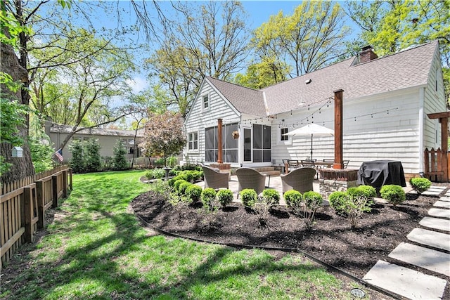 rear view of property featuring a patio, a fenced backyard, roof with shingles, a chimney, and a yard