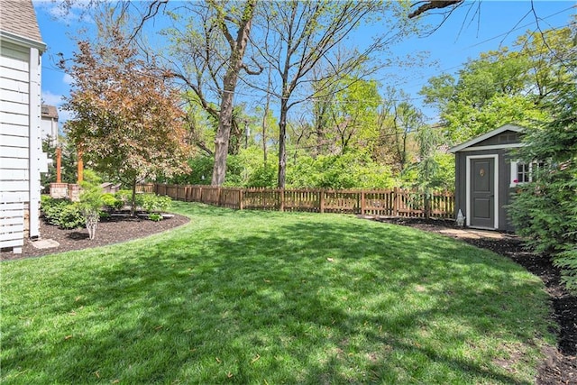 view of yard with an outdoor structure, a fenced backyard, and a storage unit