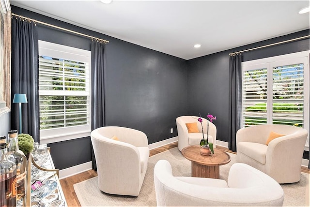 living area with recessed lighting, baseboards, wood finished floors, and a wealth of natural light