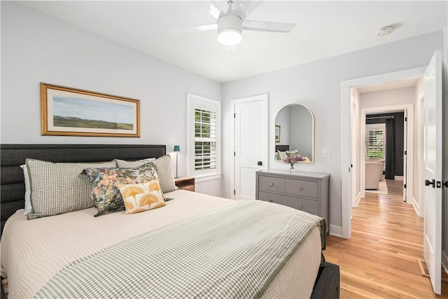 bedroom featuring a ceiling fan, baseboards, and light wood-style floors