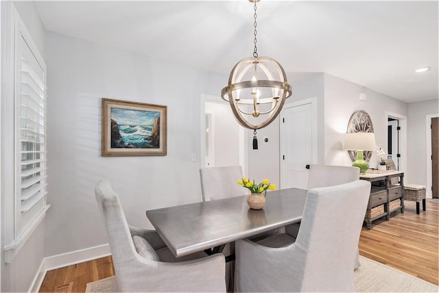 dining space with recessed lighting, baseboards, light wood finished floors, and a chandelier
