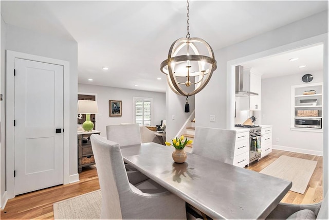 dining area with a notable chandelier, light wood-style floors, stairs, recessed lighting, and baseboards