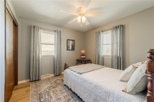 2931 N Washington St, Chillicothe, MO 64601 - bedroom with light wood-style flooring, visible vents, baseboards, a ceiling fan, and a closet