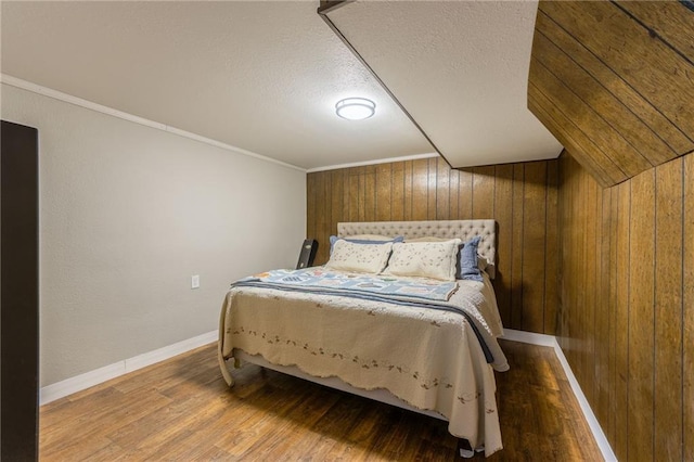 2931 N Washington St, Chillicothe, MO 64601 - bedroom with baseboards, wood finished floors, wooden walls, and a textured ceiling