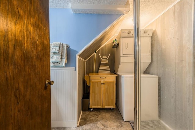 2931 N Washington St, Chillicothe, MO 64601 - laundry room with wooden walls, laundry area, stacked washer and clothes dryer, and a textured ceiling