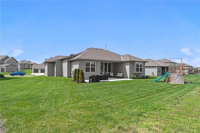 rear view of house with a yard, outdoor lounge area, a patio area, and a playground