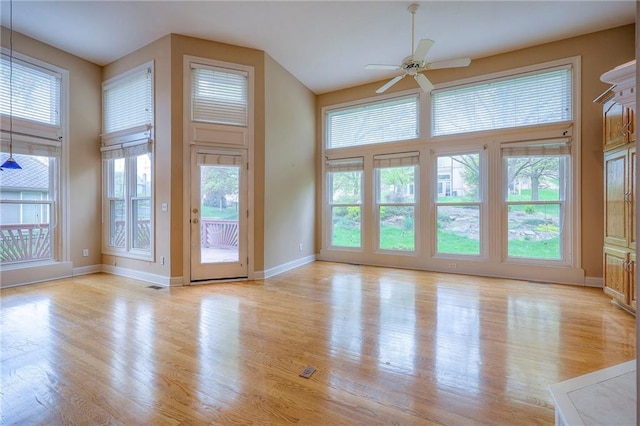unfurnished living room featuring baseboards, ceiling fan, visible vents, and light wood-style flooring
