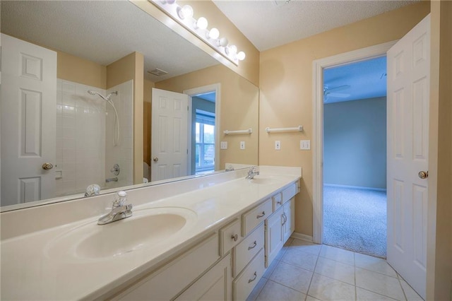 full bath with double vanity, a sink, shower / tub combination, and tile patterned floors