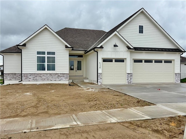 view of front of home featuring french doors, driveway, and stone siding