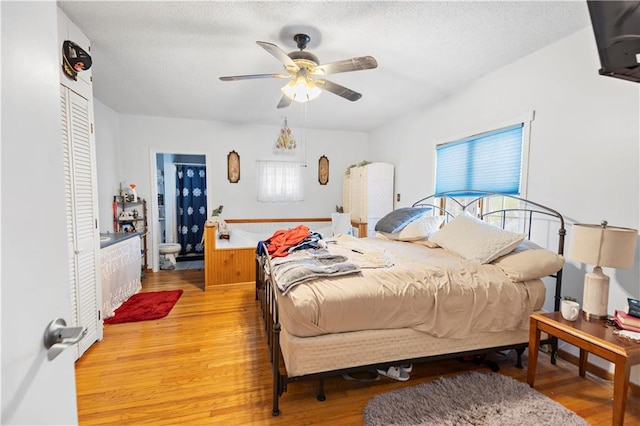 bedroom featuring a ceiling fan, a textured ceiling, light wood-style floors, and a closet