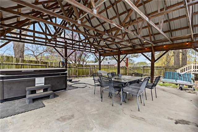 view of patio / terrace featuring outdoor dining space, a hot tub, and a fenced backyard