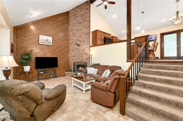 2501 Olde Creek Ct S, Leavenworth, KS 66048 - living area with high vaulted ceiling, wood walls, a ceiling fan, stairway, and a brick fireplace